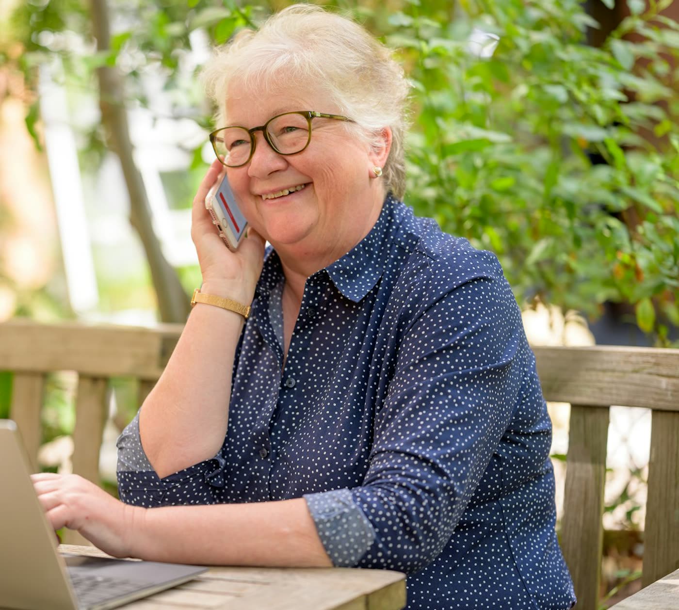 An older woman smiling while talking on the phone