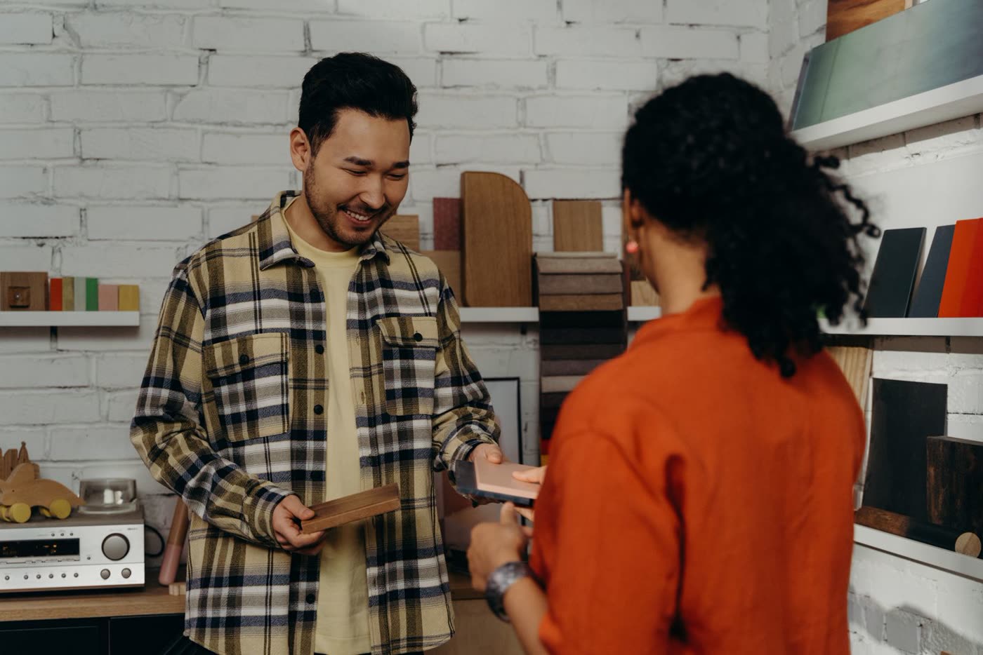 A salesperson walking a business owner through product samples in a showroom