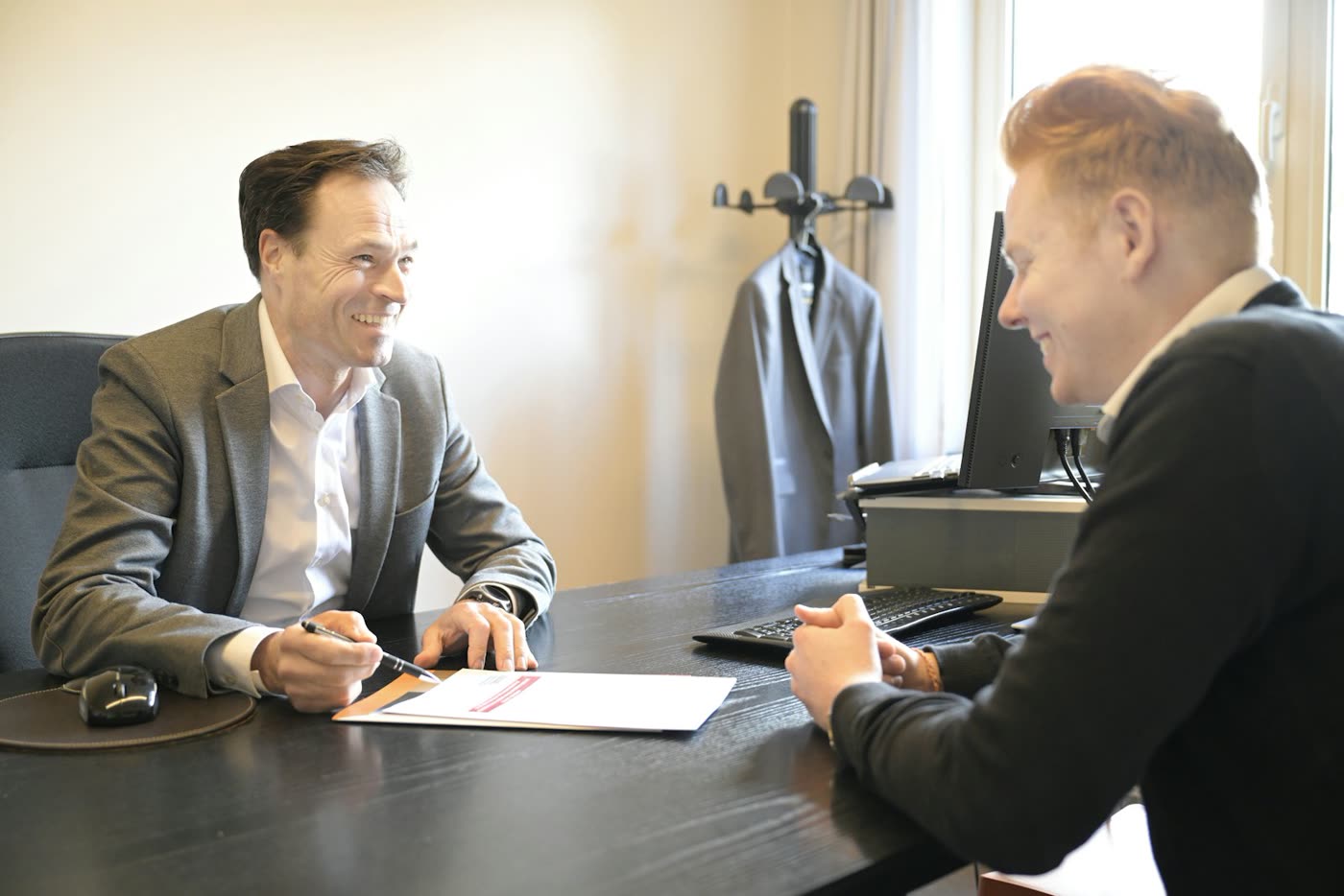 Two professionals going over a document across an office desk